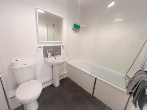 a white bathroom with a toilet and a sink at Gorgeous apartment with free parking in Southampton