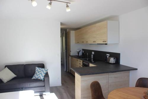 uma cozinha e sala de estar com um sofá e uma mesa em La petite Rascasse, Appartement avec Terrasse ensoleillée em Rayol-Canadel-sur-Mer