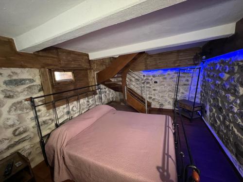 - une chambre avec un lit dans une pièce dotée d'un mur en pierre dans l'établissement L’antico casale, à Reggio de Calabre