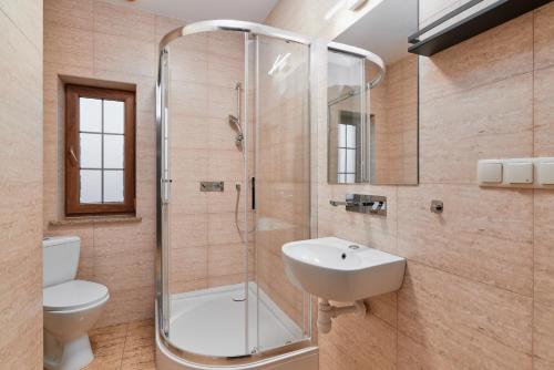 La salle de bains est pourvue d'une douche, de toilettes et d'un lavabo. dans l'établissement Artis Dom Gościnny, à Zamość