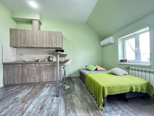 a bedroom with a bed and a kitchen with a window at Central Park Apartment on Sumskaya in Kharkiv