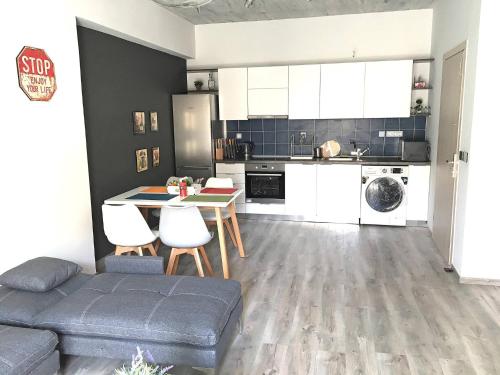 una cucina con divano e tavolo in una camera di Pegasus Amazing Flat, 1,5min Walk To The Beach a Chania
