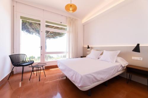 馬塔羅的住宿－Catalunya Casas Seafront bliss for 16 people 40km to Barcelona!，卧室配有白色的床、书桌和椅子
