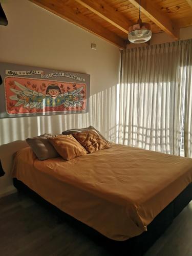 1 cama grande en un dormitorio con ventana en Valen House en Malargüe