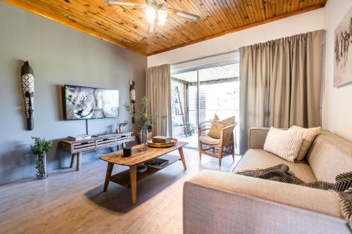 a living room with a couch and a table at Feather Nest Guest House in Oudtshoorn