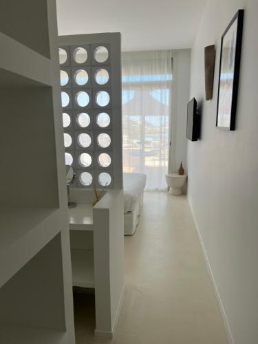 a white room with a bed and a window at Hotel La Potiniere in Hyères