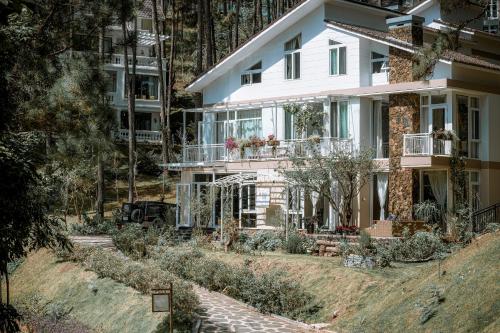 a white house with a garden in front of it at Dahlia Dalat in Xuan An