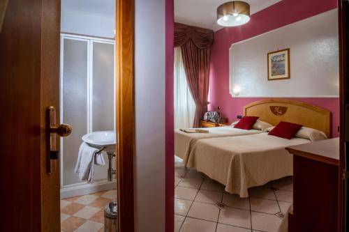 a hotel room with two beds and a sink at Hotel Savoia Sorrento in Sorrento