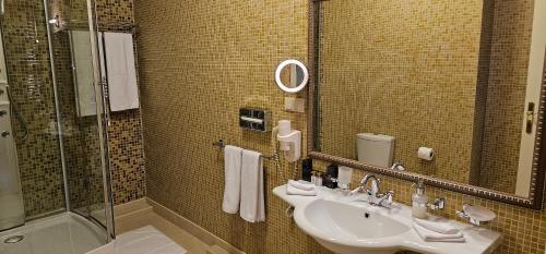 a bathroom with a sink and a shower at Savoy Hotel in Chişinău