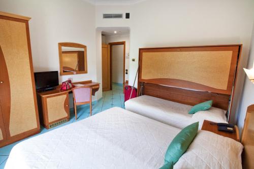 a hotel room with two beds and a television at Hotel Savoia Sorrento in Sorrento