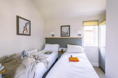 two beds in a room with white walls at The Bay Filey in Filey