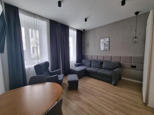 a living room with a couch and a table at BOOGIE Home Kamienica Łódzka in Łódź
