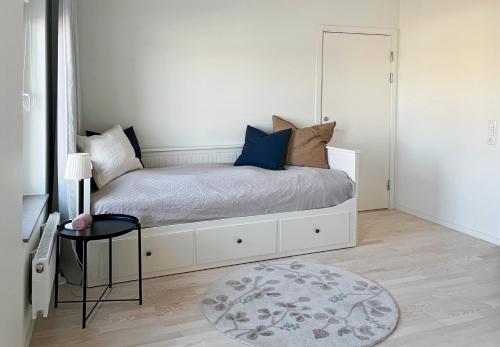 a bedroom with a white bed with a rug at Hyllie Appartement - New Construction in Malmö