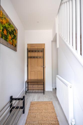 a hallway with a wooden door and a rug at The Ramey in Sheringham