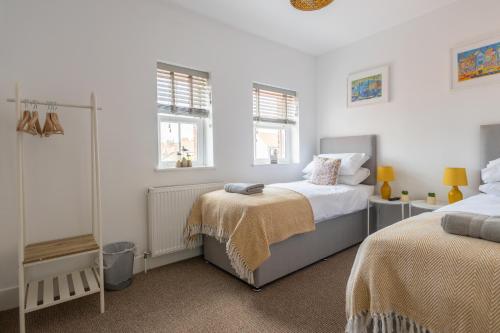 a bedroom with two beds and two windows at The Ramey in Sheringham