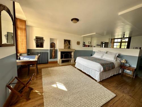 - une chambre avec un lit, une table et un bureau dans l'établissement Le Prieuré sur Seine, à Marnay-sur-Seine