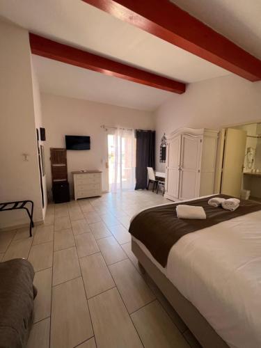 a bedroom with a bed and a television in a room at Hotel La Potiniere in Hyères