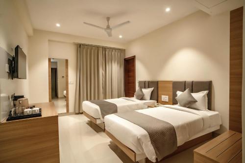 a hotel room with two beds and a television at THE MANGAL VIEW RESIDENCY - A Luxury Boutique Business Hotel in Udaipur