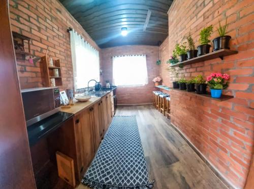 a kitchen with a brick wall and a sink at Chale Greifswald Pomerode in Pomerode