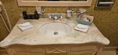 a bathroom sink with a marble counter top at Savoy Hotel in Chişinău