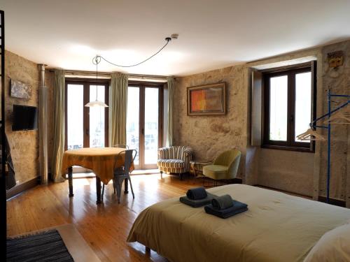 a bedroom with a bed and a table and chairs at Framer's House - Authentic Downtown in Porto