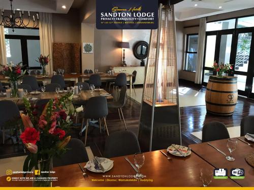a restaurant with tables and chairs and a sign that says sandon lodge at Sandton Lodge Rivonia in Johannesburg