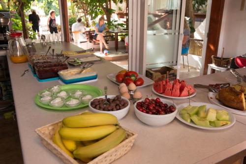 a counter with bowls of fruits and vegetables on it at Nikos Hotel in Matala