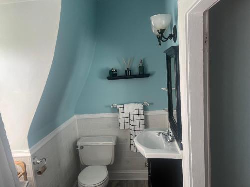 La salle de bains est pourvue de toilettes blanches et d'un lavabo. dans l'établissement Private Victorian Apartment in convenient City location on 5 acre, Sleeps 5, à Poughkeepsie