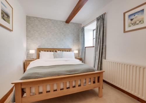 a bedroom with a large bed and a window at Ballowfield Barn in Carperby