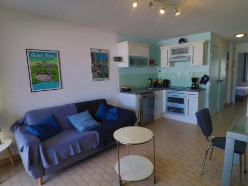 un salon avec un canapé bleu et une cuisine dans l'établissement Beau T2 à Sète avec loggia vitrée, vue mer et marina - FR-1-472-131, à Sète