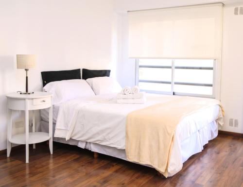 1 dormitorio blanco con 1 cama con 2 toallas en Moderno y Selecto! Buenos Aires - Villa Urquiza en Buenos Aires