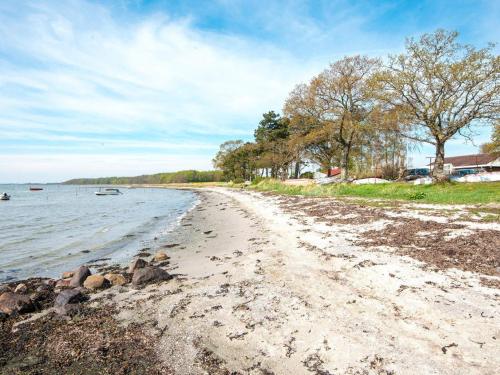 a sandy beach next to a body of water at 8 person holiday home in Odder-By Traum in Odder