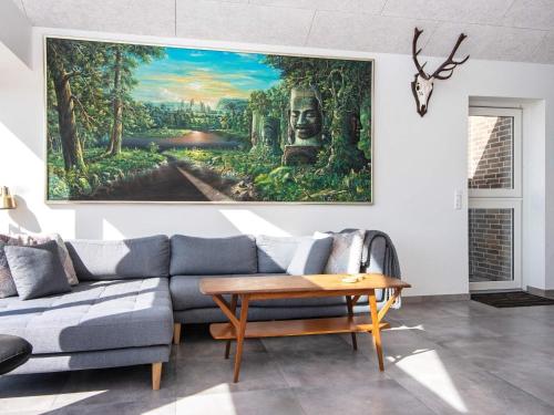 a living room with a couch and a painting on the wall at 8 person holiday home in Odder-By Traum in Odder