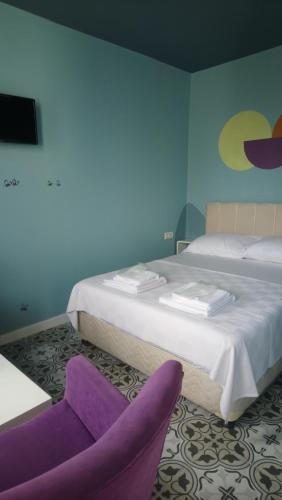 a hotel room with two beds and a purple chair at 5RoomsPansiyon in Edirne