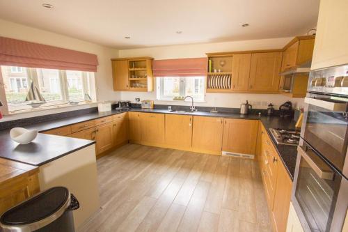 a large kitchen with wooden cabinets and a wooden floor at The Bay Filey in Filey