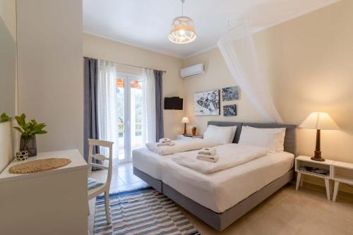 1 dormitorio con 2 camas, escritorio y ventana en Kapella Country House, en Vátos
