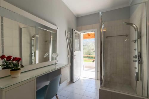 a bathroom with a shower and a sink and a mirror at Kapella Country House in Vátos