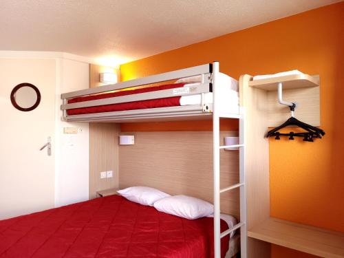 ein Schlafzimmer mit einem Etagenbett mit einer roten Tagesdecke in der Unterkunft Premiere Classe Metz Nord - Semecourt in Fèves