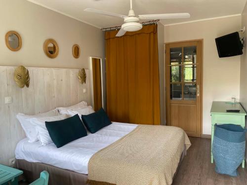 una camera con un grande letto e un ventilatore a soffitto di l'Océane a Lège-Cap-Ferret