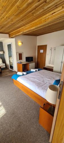 a bedroom with a large bed with a wooden ceiling at Mirana Family Hotel in Burgas City