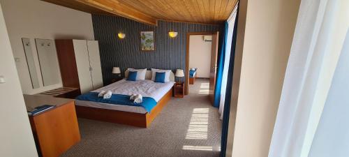 a bedroom with a bed with blue sheets and blue pillows at Mirana Family Hotel in Burgas City