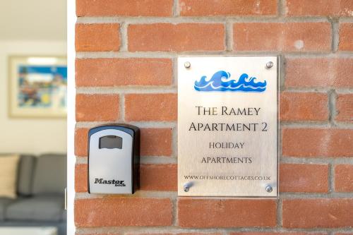 a brick wall with a sign for the ramiagency apartment gmaxwellauts at The Ramey in Sheringham