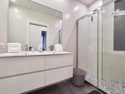 une salle de bain blanche avec une douche et un lavabo dans l'établissement Appartement 'EMILIA', à Nice