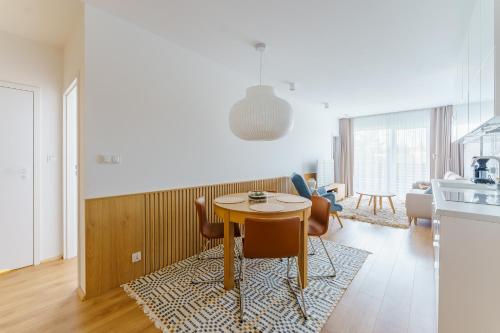 cocina y comedor con mesa y sillas en Apartament DUNE SurfingBird Dźwirzyno, en Dźwirzyno