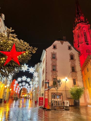 uma rua da cidade à noite com luzes de Natal em Gîte des Victoires em Mulhouse