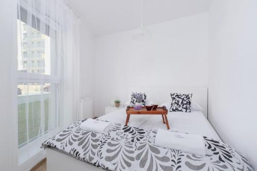a white bedroom with a bed and a table at Family Apartment with Parking & Terrace by Renters in Kraków