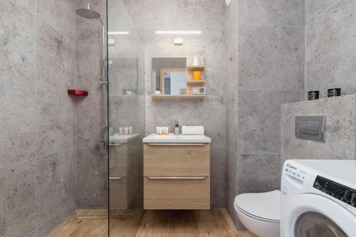 a bathroom with a toilet and a sink and a shower at Family Apartment with Parking & Terrace by Renters in Kraków