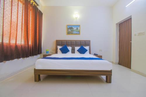 a bedroom with a large bed with blue pillows at The panachi in Mathura