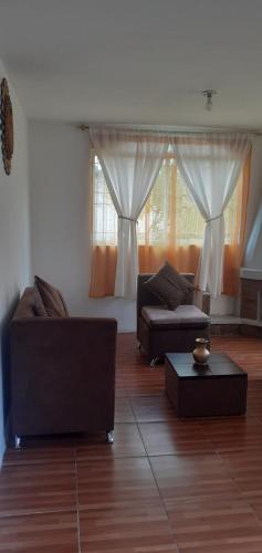 uma sala de estar com dois sofás e uma mesa em Casa campestre en las faldas del Taita Imbabura em San Juan de Ilumán