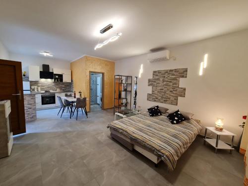 1 dormitorio con 1 cama y cocina con mesa en Studio Apartman D&D, en Brseč